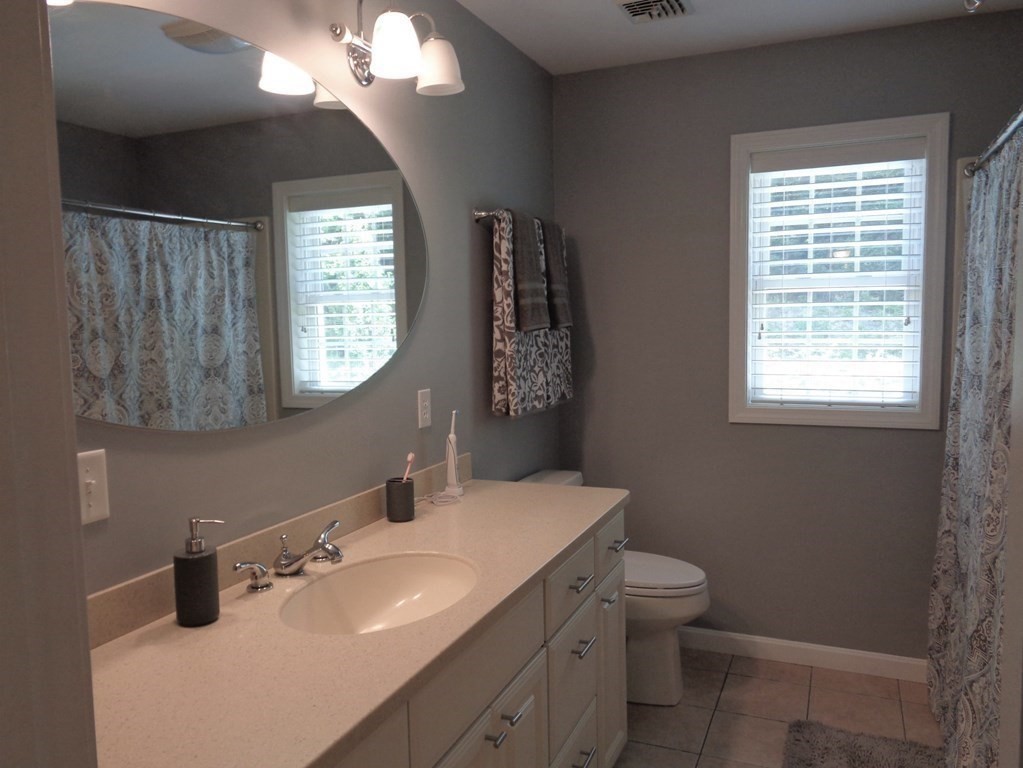 7 R Oxbow Road Oxford, MA 01537 - Photo 35 of 40 a bathroom with a toilet a sink a mirror a window and vanity