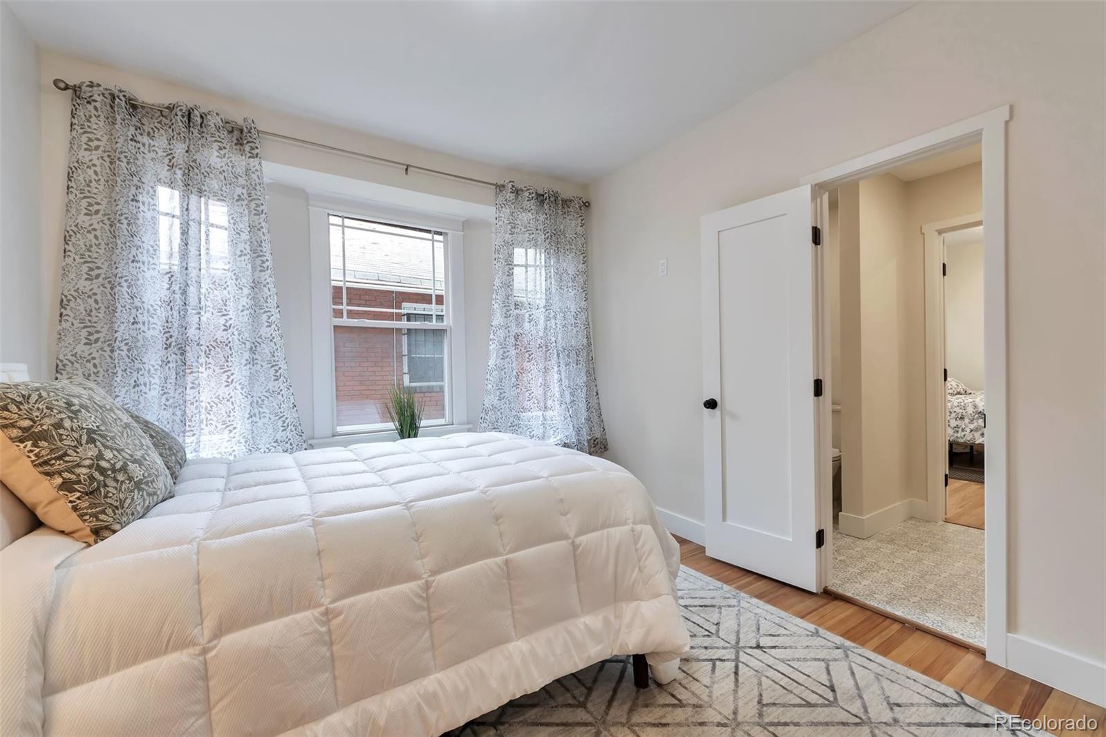 1417 Monroe Street Denver, CO 80206 - Photo 24 of 43 a bedroom with a bed and a window