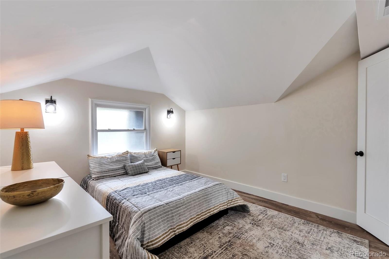 1417 Monroe Street Denver, CO 80206 - Photo 29 of 43 a bedroom with a bed and a lamp