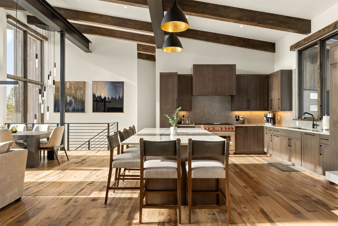 a living room with couches a dining table and chairs with wooden floor