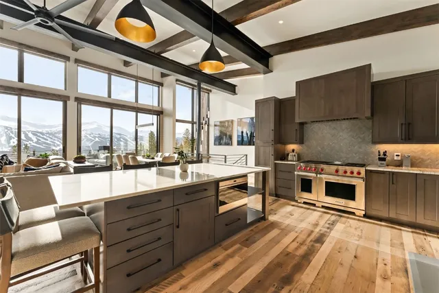 a large kitchen with stainless steel appliances granite countertop a large window and a counter space