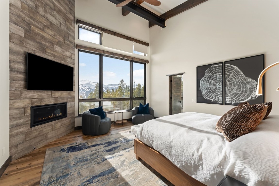 67 Marys Ridge Lane Breckenridge, CO 80424 - Photo 13 of 35 a bedroom with a large bed a flat tv screen and a fireplace
