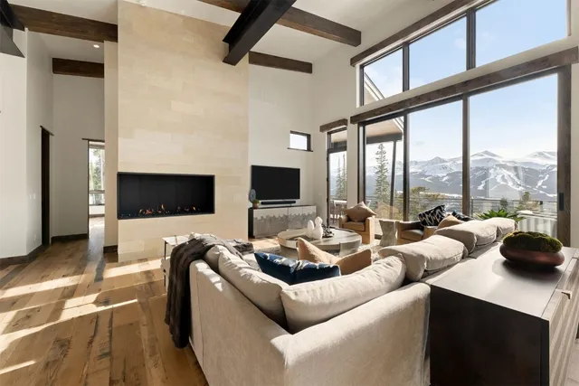 a living room with furniture a flat screen tv and a large window