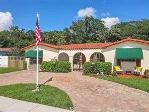 a view of a house with a yard and potted plants