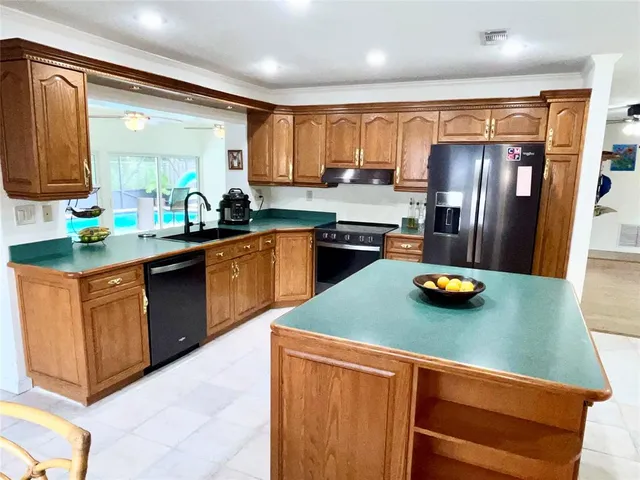 a kitchen with stainless steel appliances granite countertop a sink a stove and a refrigerator