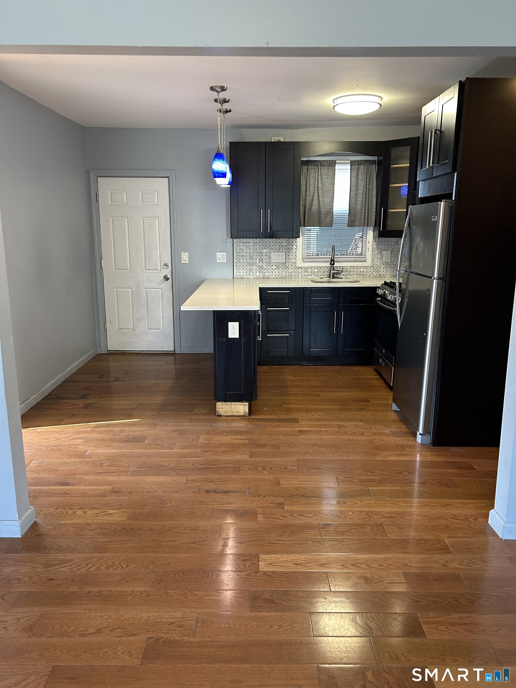 a view of kitchen with stainless steel appliances granite countertop a sink and cabinets