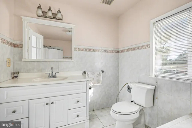 a bathroom with a toilet a sink a vanity and mirror