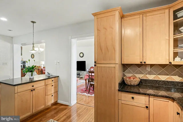 a kitchen with stainless steel appliances granite countertop a sink a stove and a wooden floors