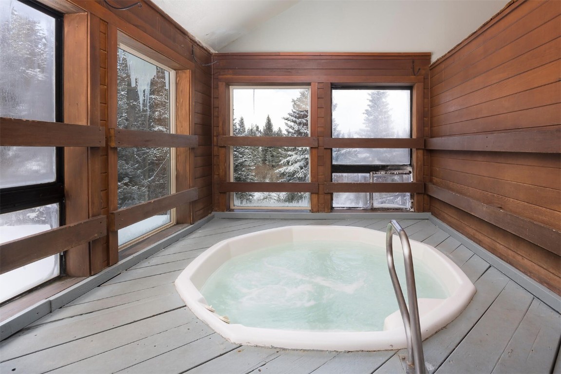 10000 Ryan Gulch Road, Unit G105 Silverthorne, CO 80498 - Photo 20 of 37 Unfurnished sunroom featuring a hot tub and vaulted ceiling