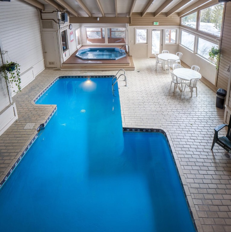 10000 Ryan Gulch Road, Unit G105 Silverthorne, CO 80498 - Photo 31 of 37 Indoor pool featuring a sunroom and a hot tub