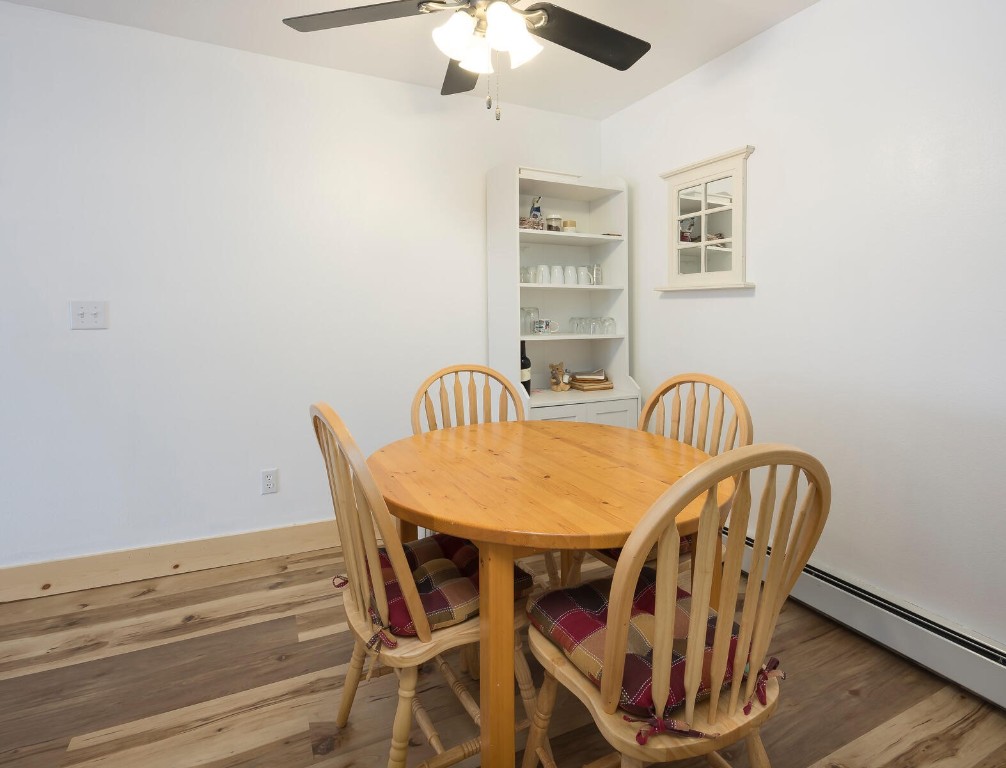 10000 Ryan Gulch Road, Unit G105 Silverthorne, CO 80498 - Photo 9 of 37 Dining area with wood finished floors, ceiling fan, and a baseboard radiator