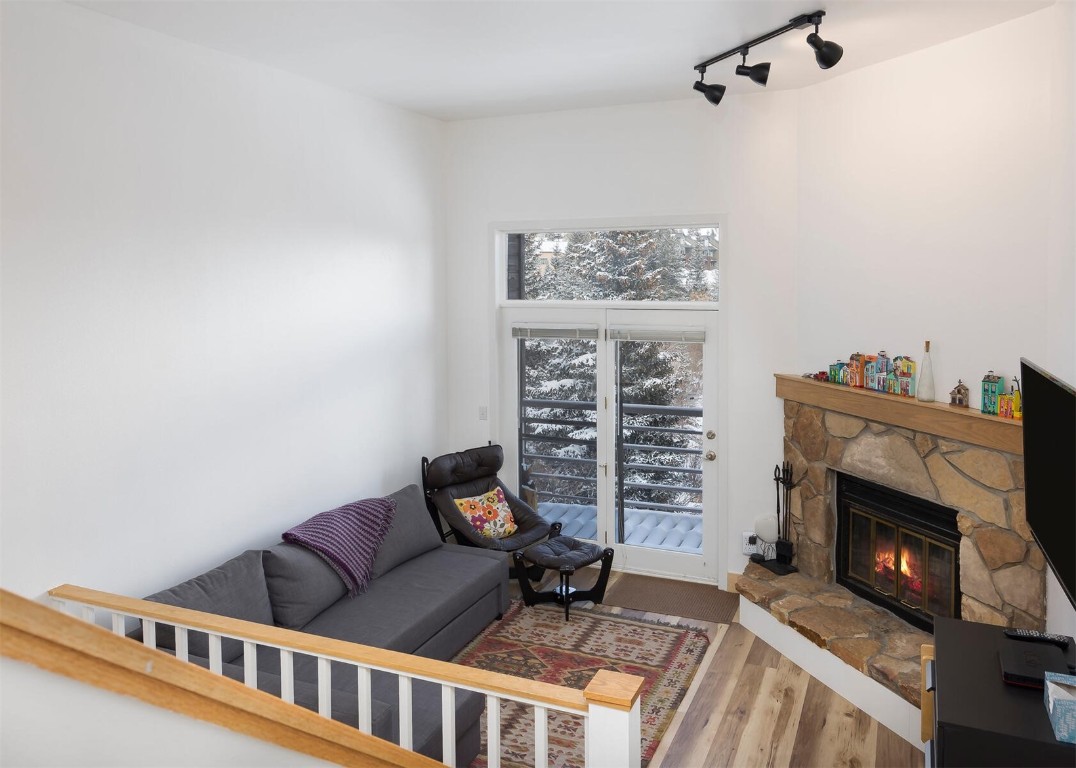 10000 Ryan Gulch Road, Unit G105 Silverthorne, CO 80498 - Photo 10 of 37 Living room with a fireplace, rail lighting, and wood finished floors