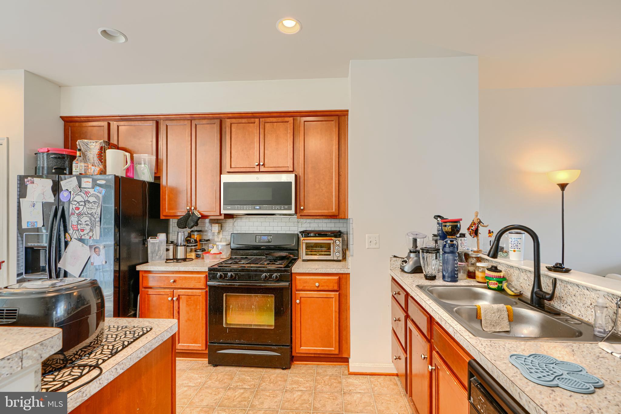 44317 Ocelot Way California, MD 20619 - Photo 25 of 45 a kitchen with stainless steel appliances granite countertop a sink stove and refrigerator
