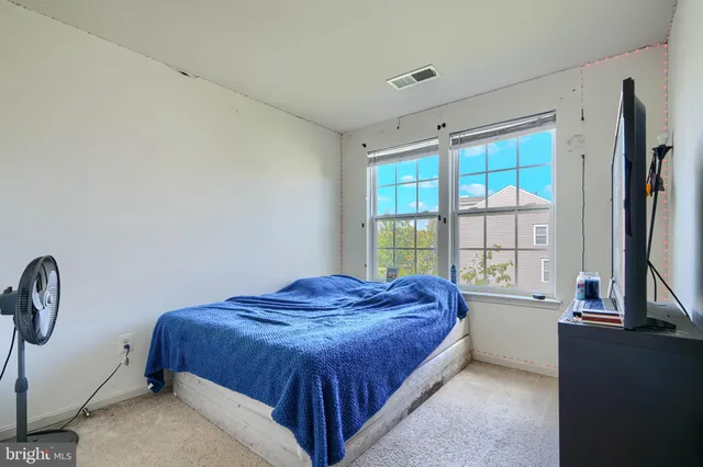 a spacious bedroom with a bed and a window