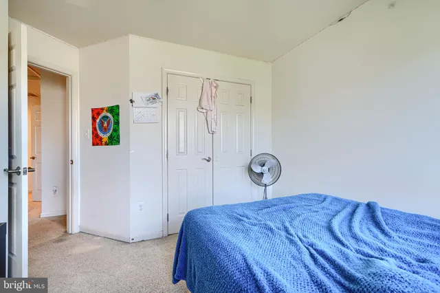 a bedroom with a bed and a painting on the wall