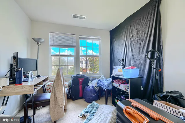 a bedroom with a bed and large windows
