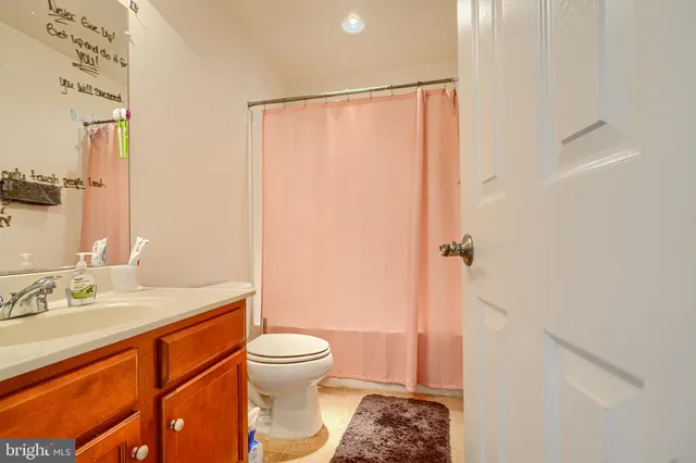 a bathroom with a sink a toilet and shower curtain