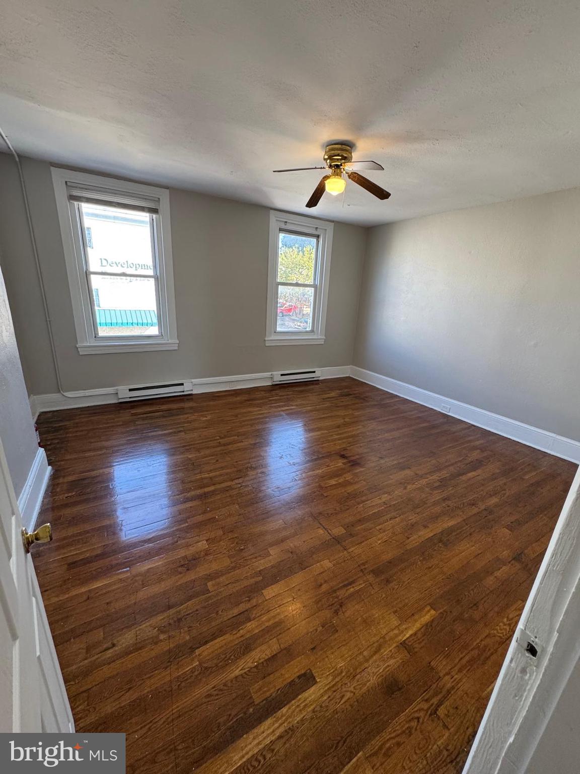 326 East Airy Street, Unit 2 Norristown, PA 19401 - Photo 5 of 8 an empty room with wooden floor chandelier fan and windows