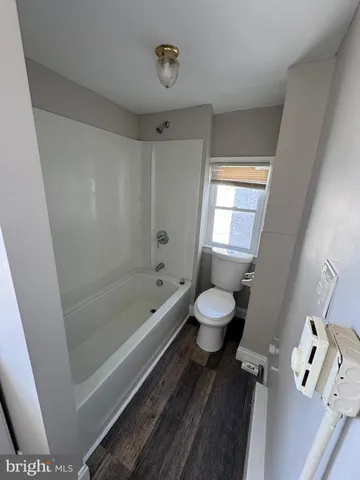 a bathroom with a toilet a sink a mirror a bathtub and vanity