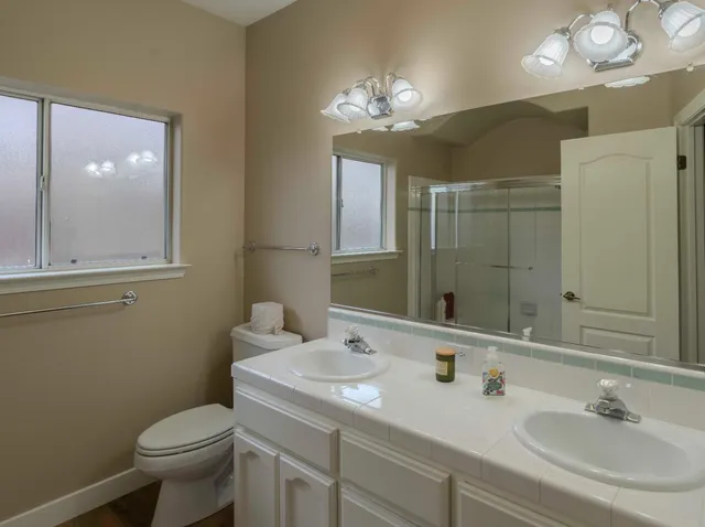 a bathroom with a toilet sink and mirror