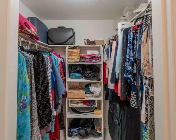 a view of walk in closet with clothes and shoes