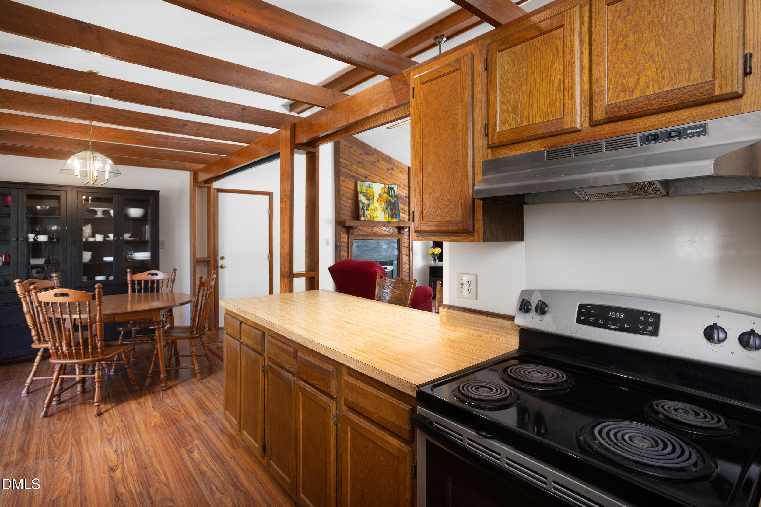 5520 Round Hill Lane Raleigh, NC 27616 - Photo 11 of 29 a kitchen with a stove and wooden cabinets