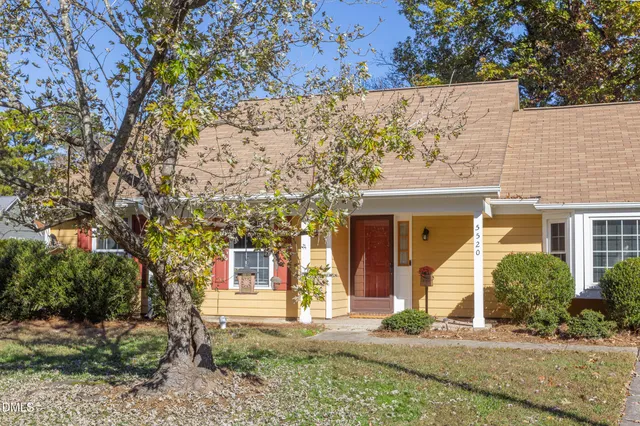 front view of a house with a yard and potted plants