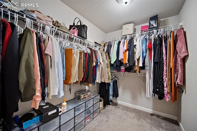 a view of walk in closet with clothes