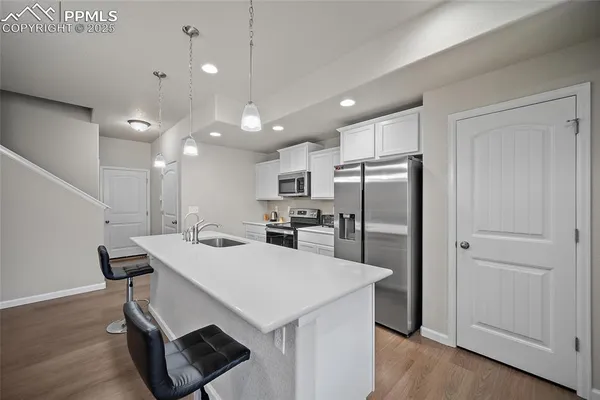 a kitchen with a refrigerator a sink dishwasher with a dining table and chairs