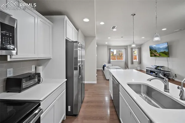 a kitchen with stainless steel appliances granite countertop a sink a stove and a refrigerator