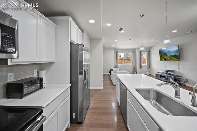 a kitchen with stainless steel appliances granite countertop a sink a stove and a refrigerator