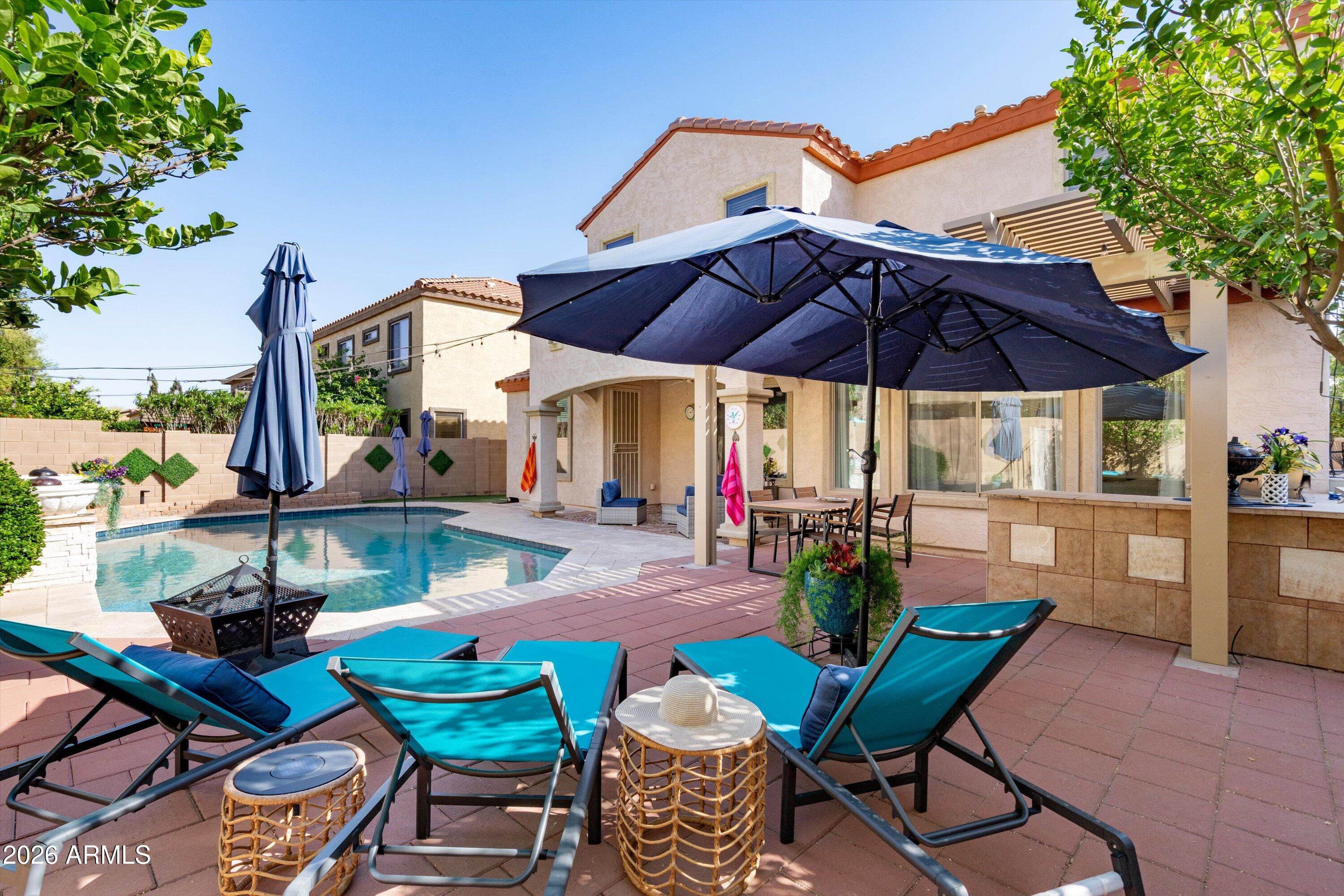 a view of a table and chairs under an umbrella in patio with a yard