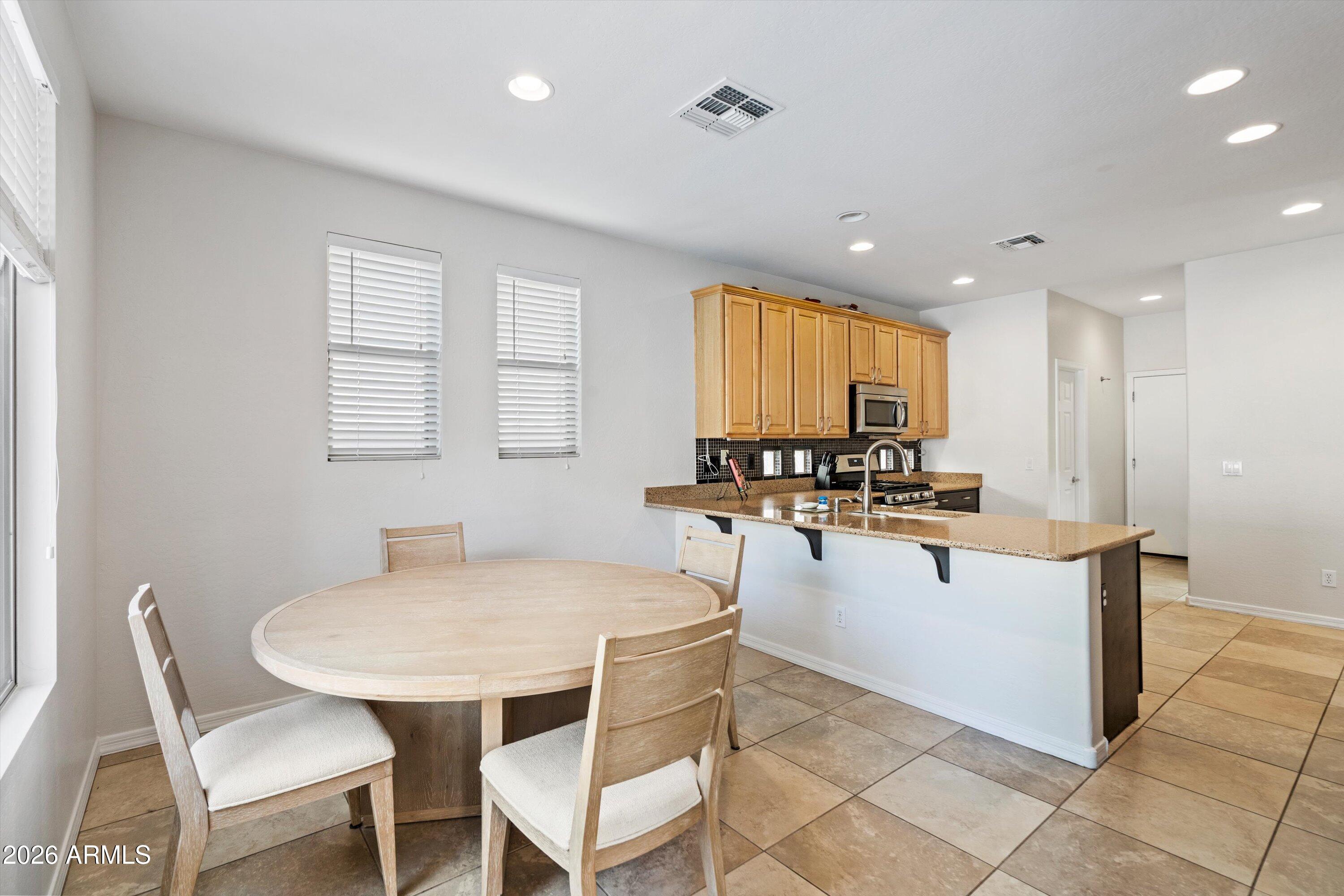 16018 West Shangri La Road Surprise, AZ 85379 - Photo 23 of 40 a kitchen with a table chairs and microwave