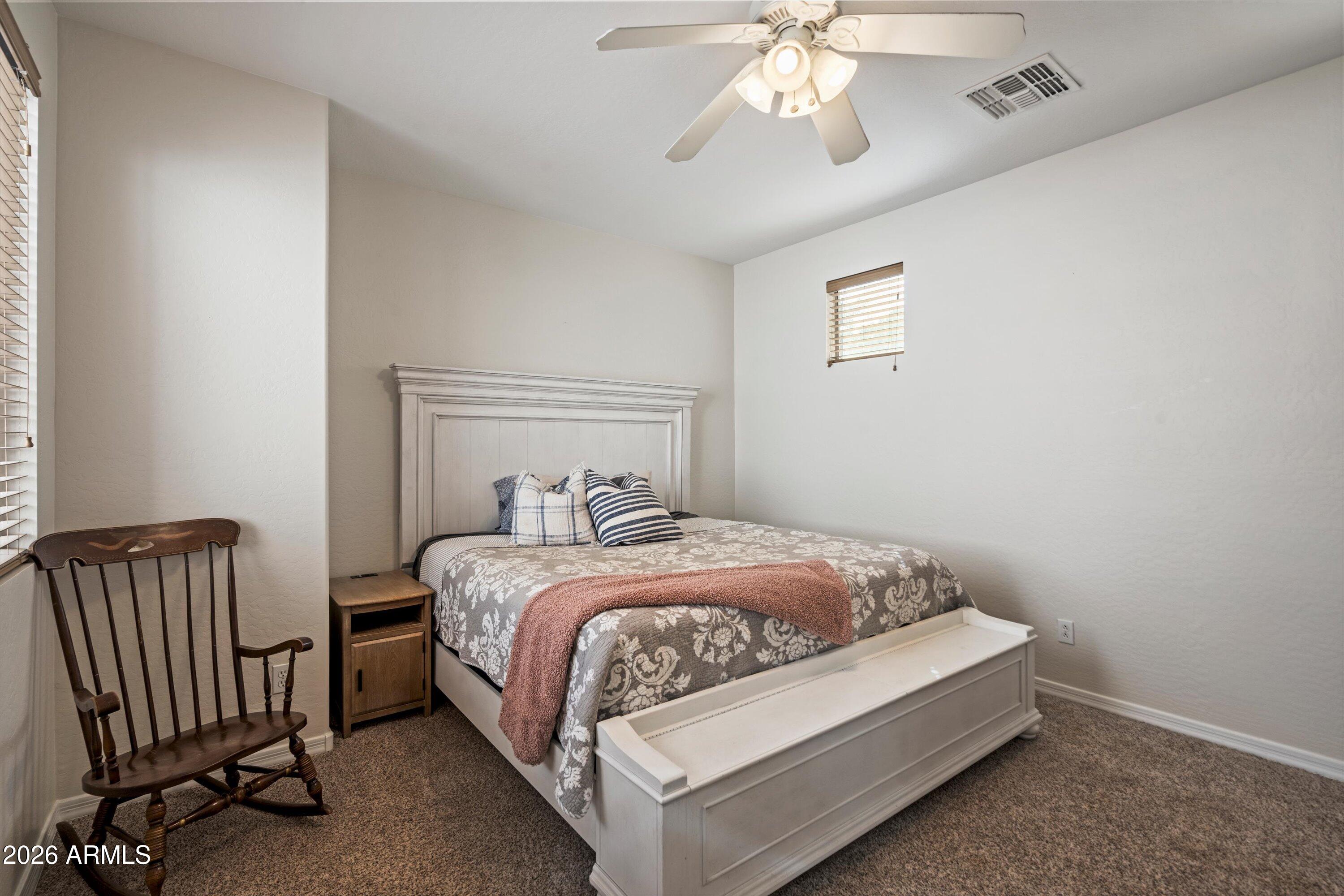 16018 West Shangri La Road Surprise, AZ 85379 - Photo 25 of 40 a bedroom with a bed and a chandelier