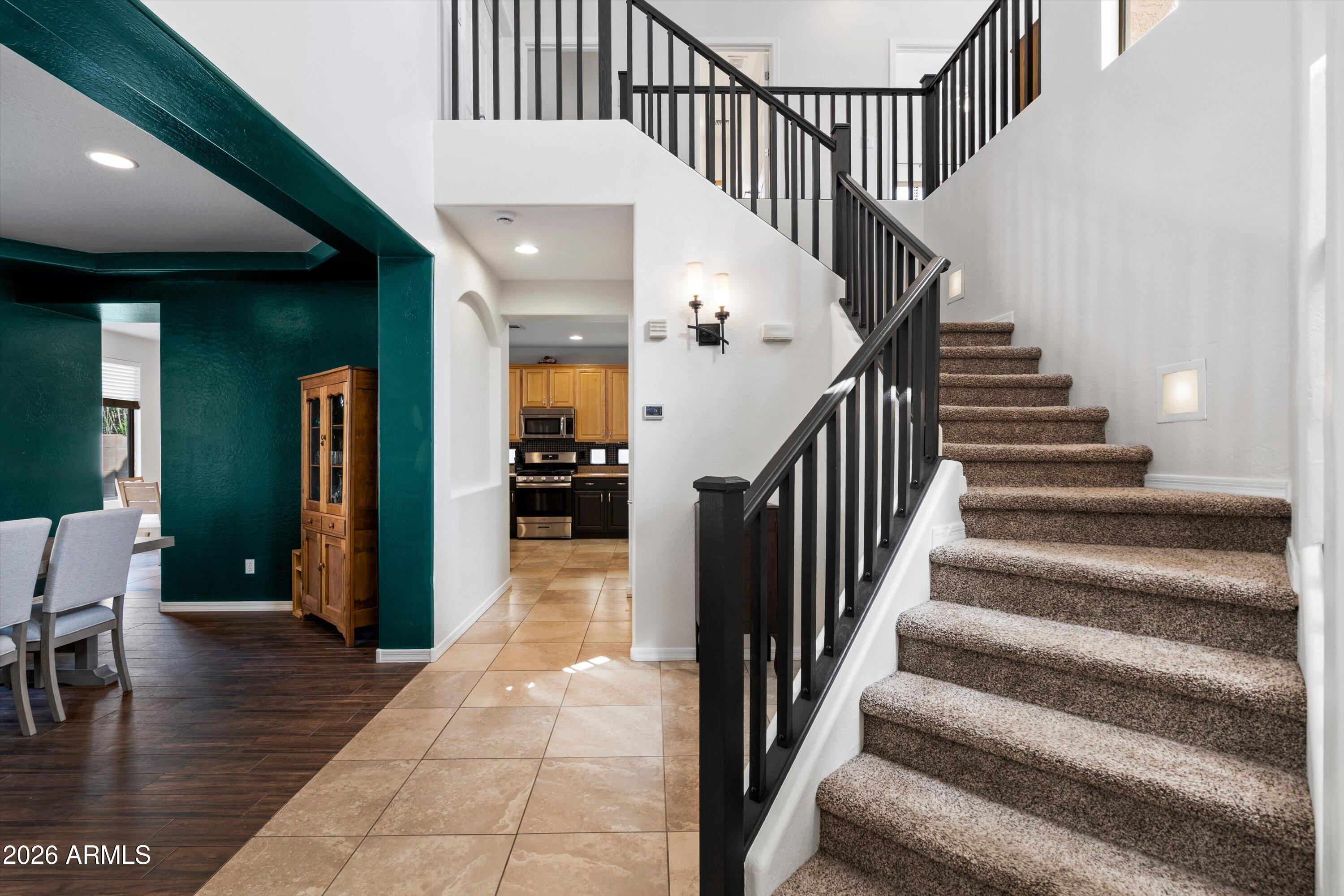 16018 West Shangri La Road Surprise, AZ 85379 - Photo 26 of 40 a view of staircase with lots of frames and frames on wall with wooden floor and a dining table