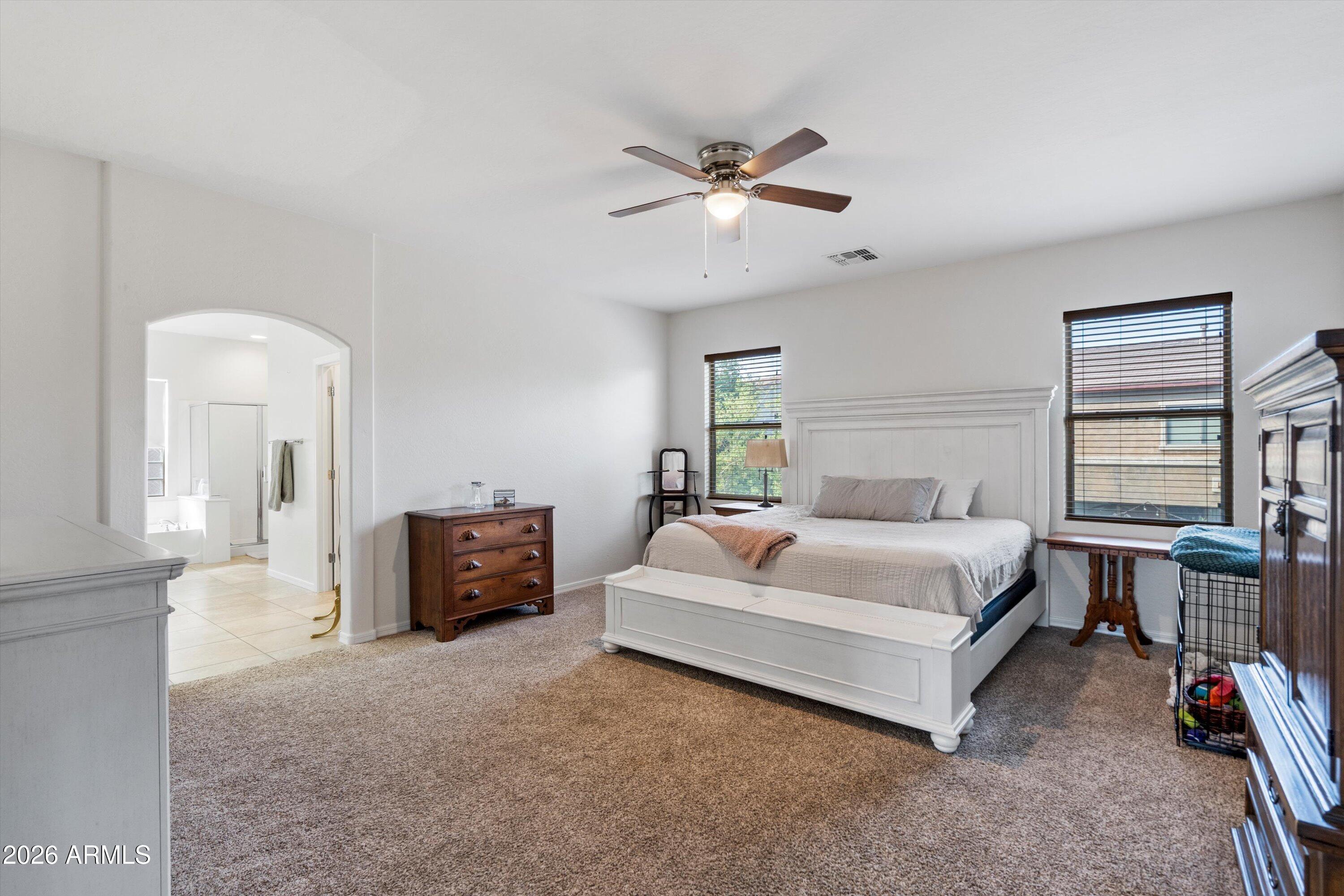 16018 West Shangri La Road Surprise, AZ 85379 - Photo 27 of 40 a spacious bedroom with a bed and a chandelier