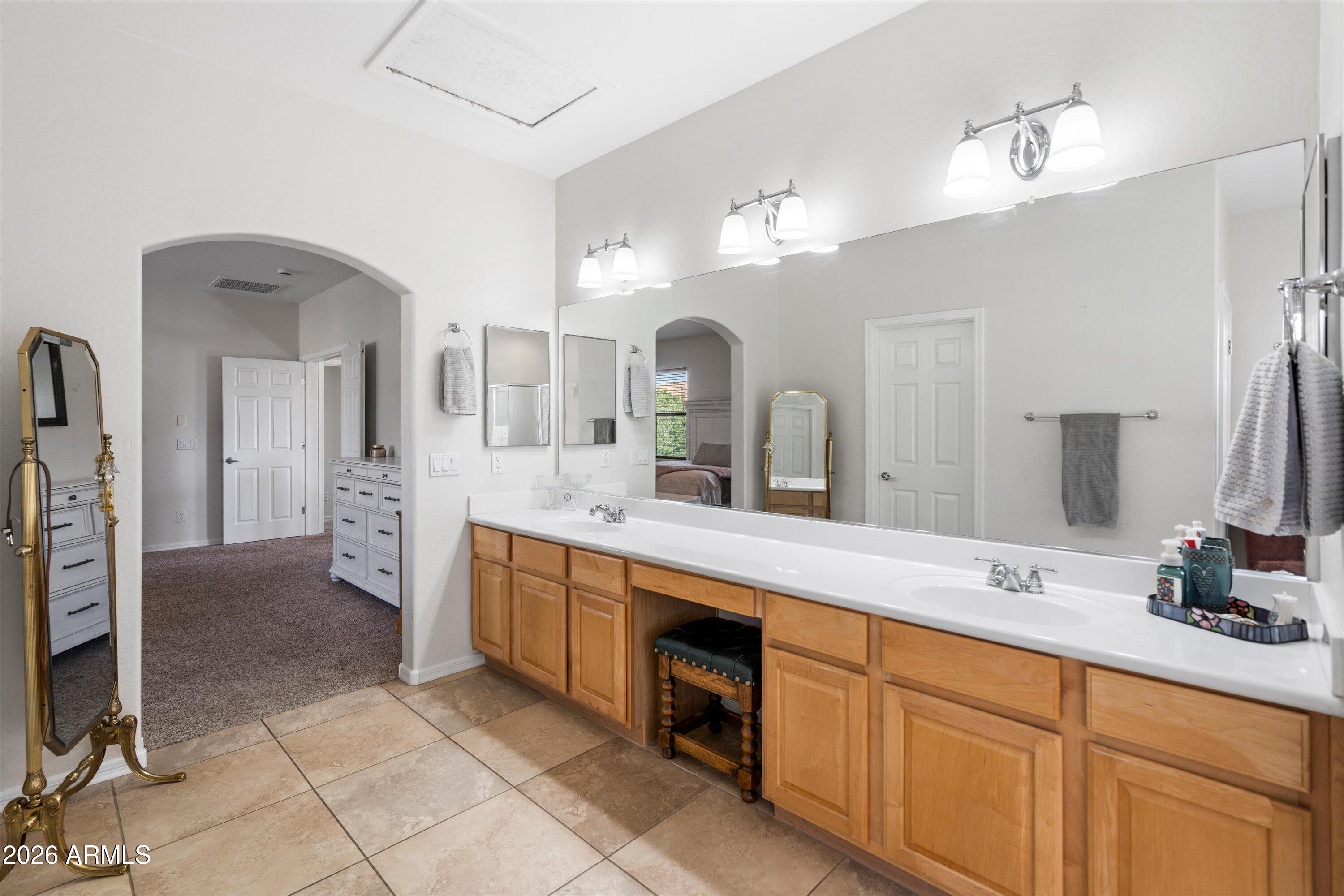 16018 West Shangri La Road Surprise, AZ 85379 - Photo 29 of 40 a spacious bathroom with a double vanity sink a mirror and a shower
