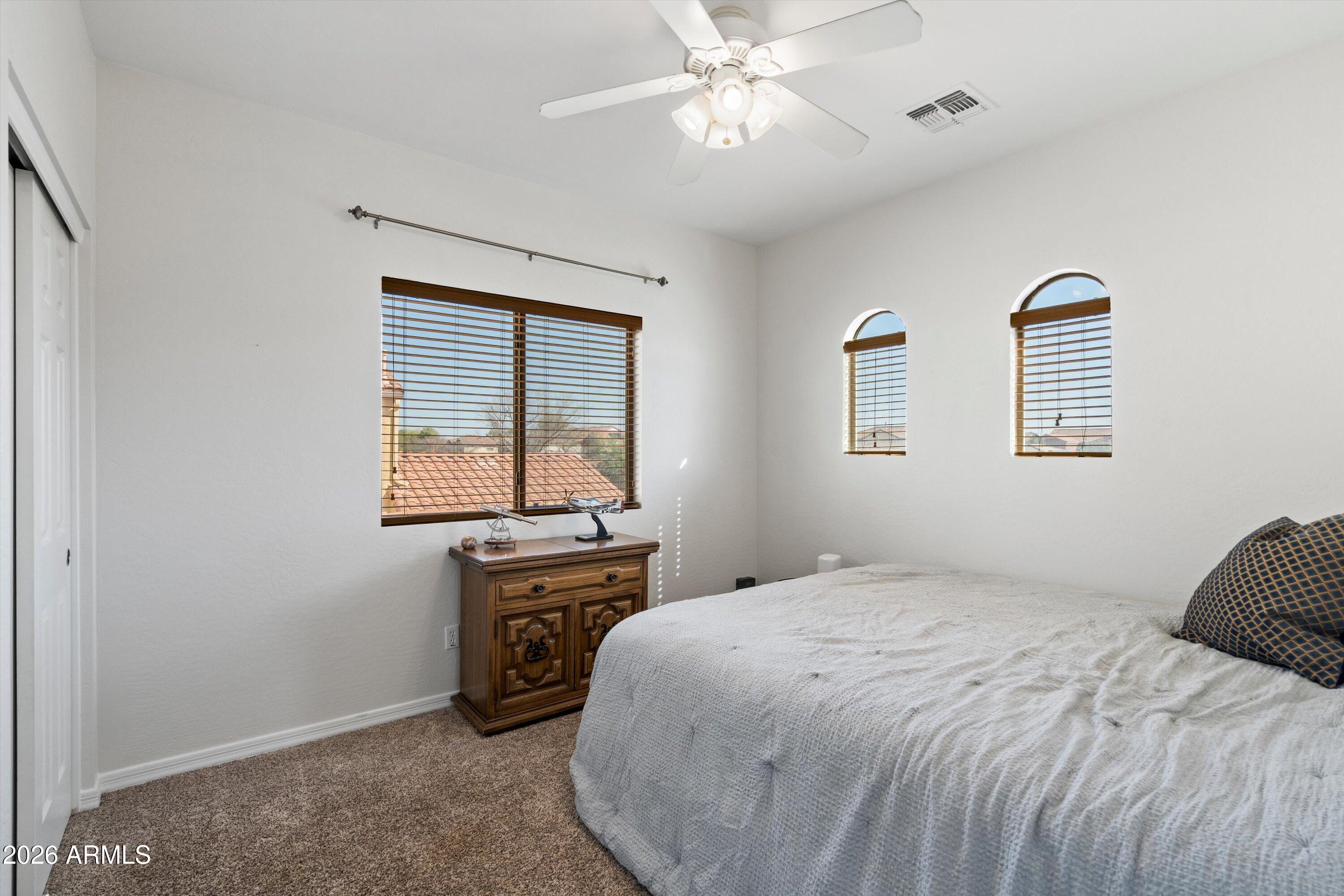 16018 West Shangri La Road Surprise, AZ 85379 - Photo 32 of 40 a bedroom with a bed and a chandelier