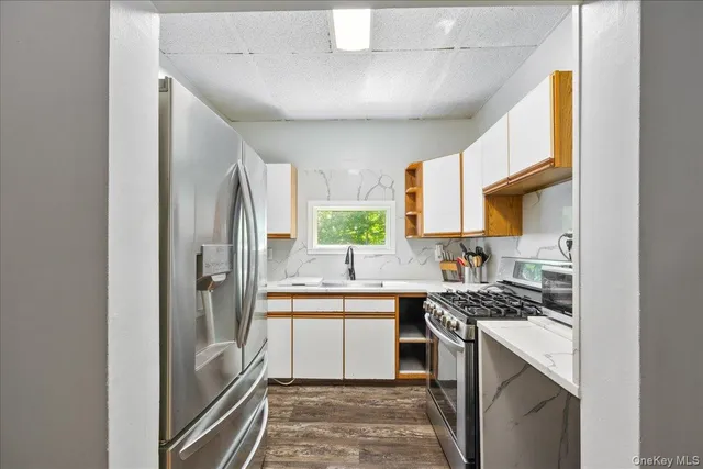 a kitchen with stainless steel appliances a sink stove refrigerator and cabinets