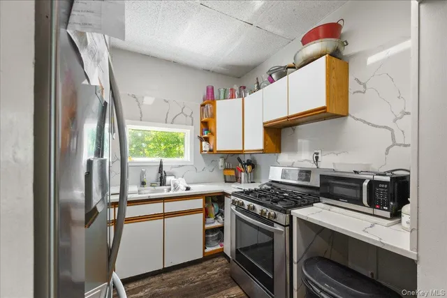 a kitchen with stainless steel appliances a sink stove and refrigerator