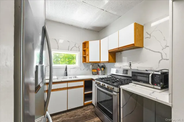 a kitchen with a sink stove and microwave