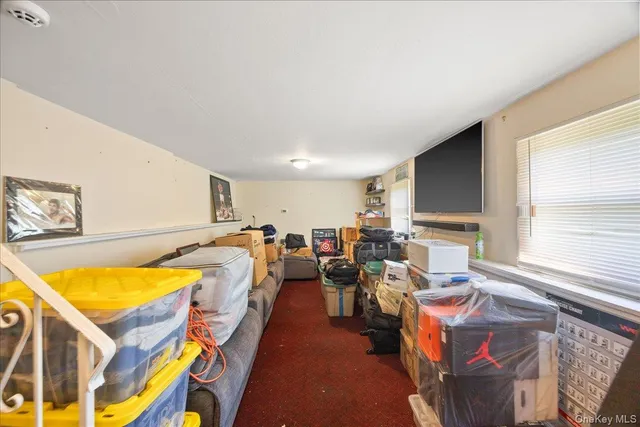 a living room with furniture a window and a flat screen tv