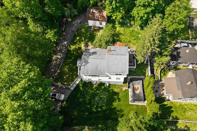 an aerial view of residential house with outdoor space and trees all around