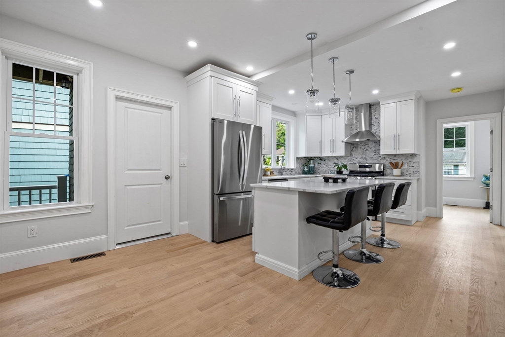 31 Rodman Street, Unit 2 Boston, MA 02130 - Photo 1 of 40 a kitchen with kitchen island a refrigerator a counter top space appliances and a window