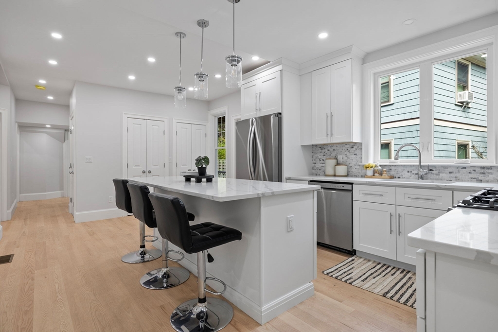 31 Rodman Street, Unit 2 Boston, MA 02130 - Photo 2 of 40 a kitchen with kitchen island a sink stainless steel appliances and cabinets