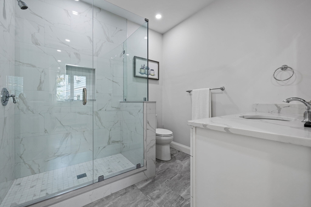 31 Rodman Street, Unit 2 Boston, MA 02130 - Photo 22 of 40 a bathroom with a granite countertop sink mirror and toilet