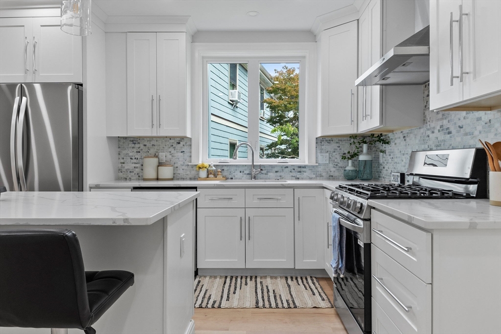 31 Rodman Street, Unit 2 Boston, MA 02130 - Photo 6 of 40 a kitchen with stainless steel appliances a stove a sink and a refrigerator