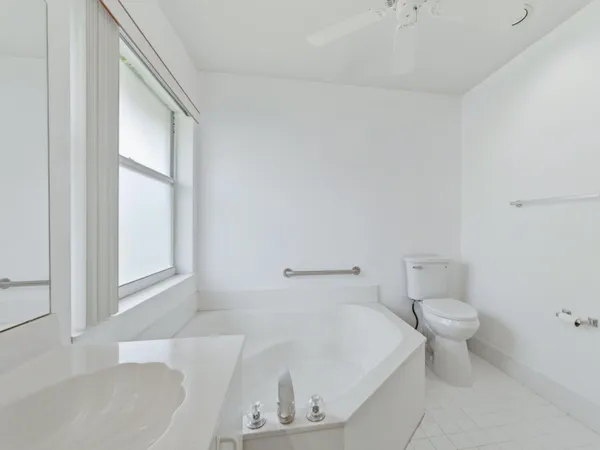 a bathroom with a white toilet and a bathtub