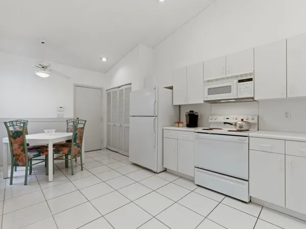 a kitchen with white cabinets and white appliances