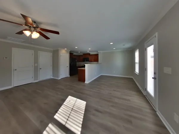 a view of an empty room and a kitchen